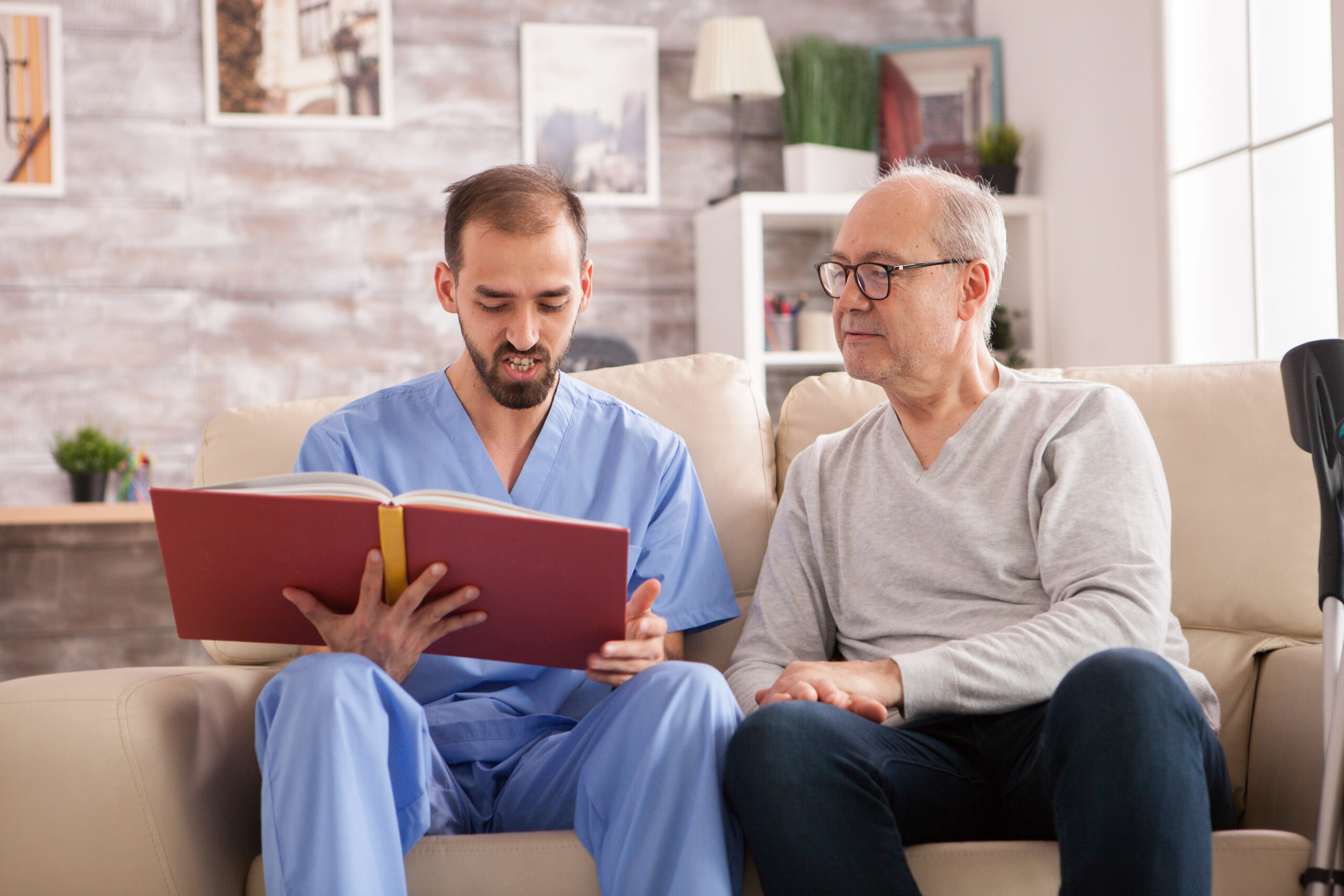 Happy senior woman in nursing home while doctor is reading a book.